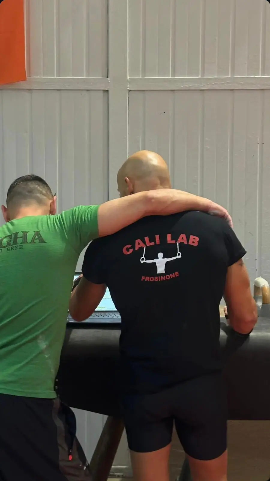 due atleti che leggono insieme la scheda di allenamento