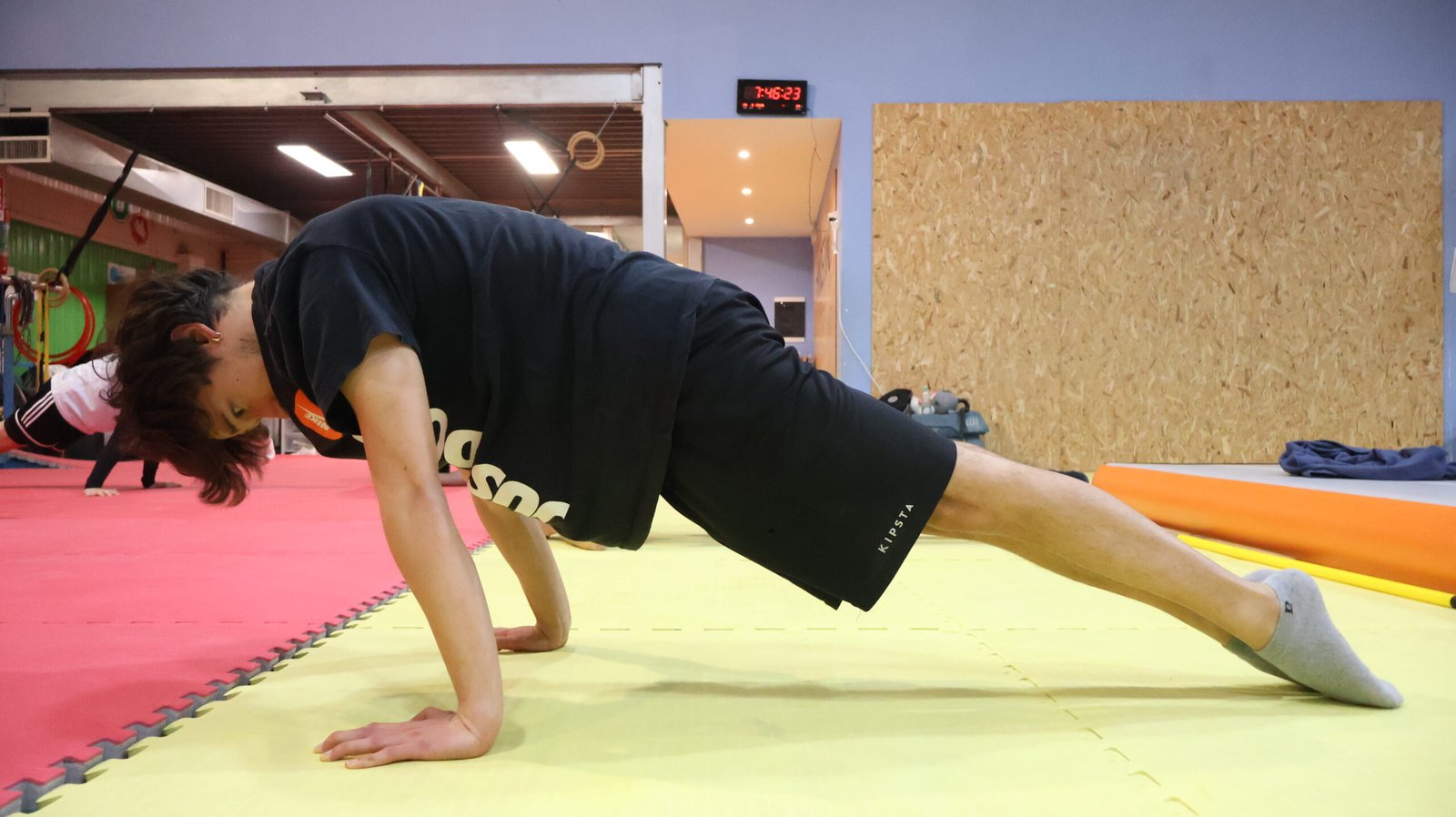 Esecuzione di planche lean su tatami per il condizionamento delle spalle e dei polsi